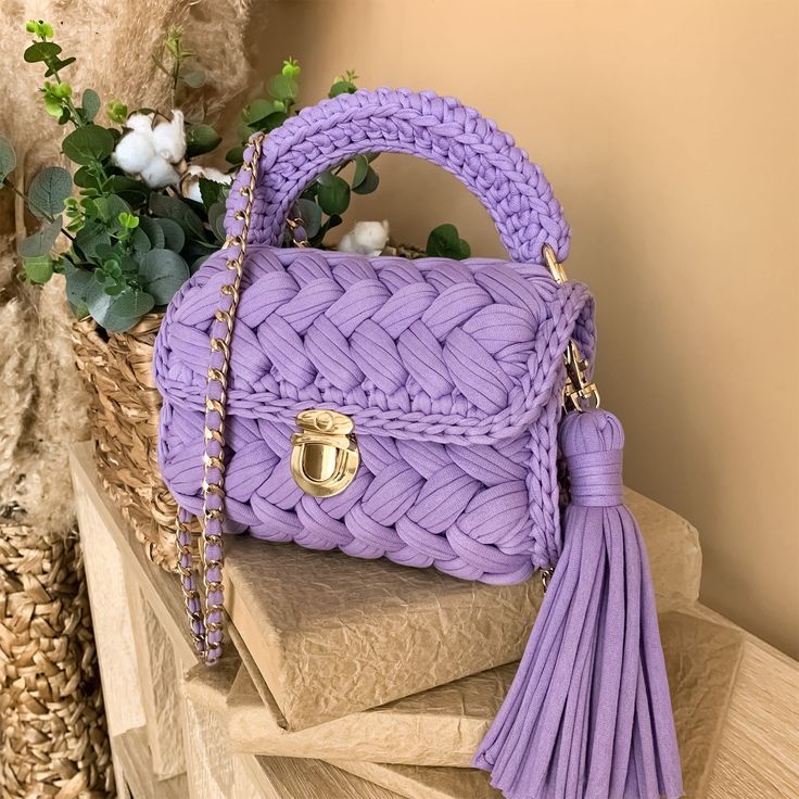 Bolso lila tejido en trapillo con asa, cadena dorada y borla